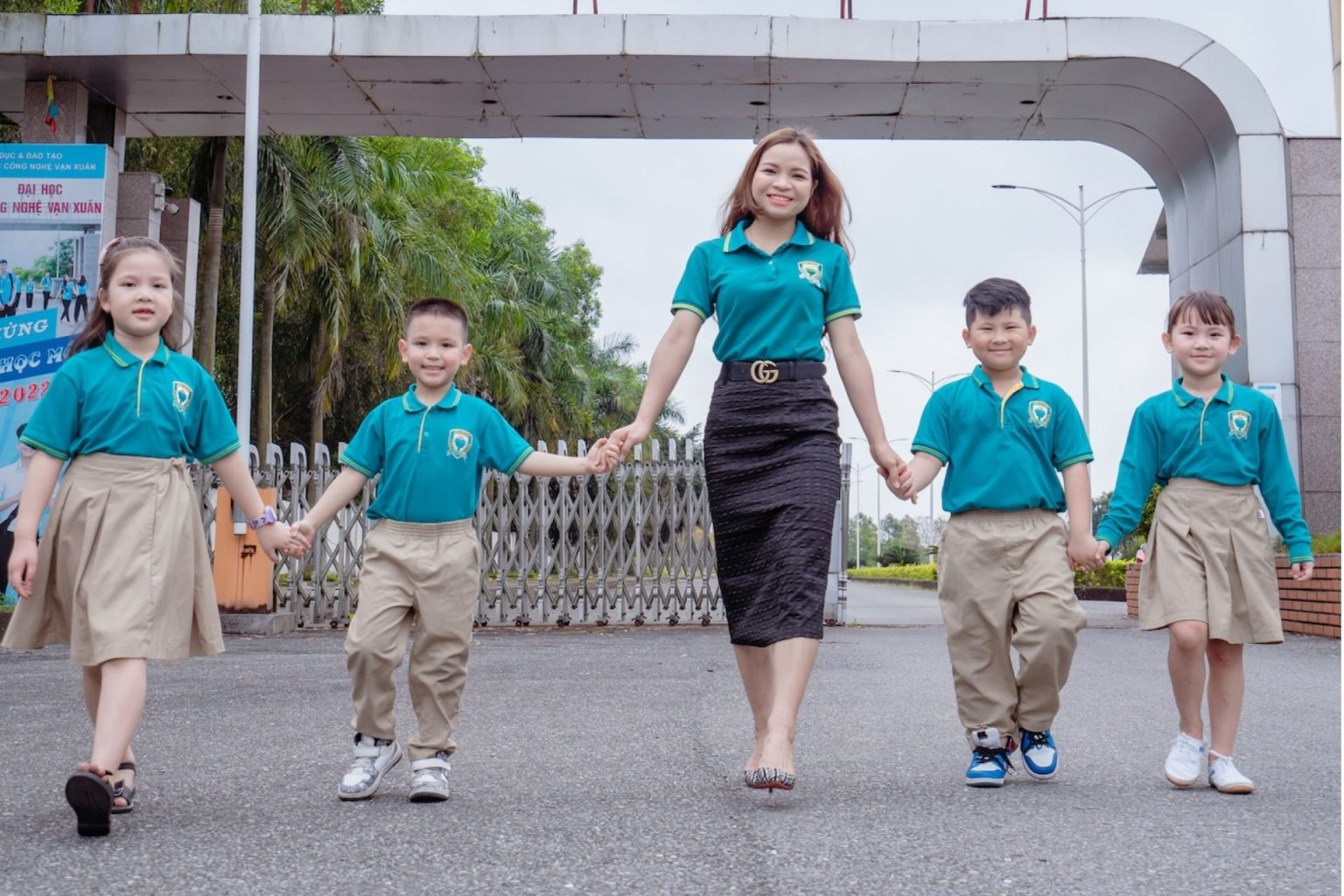 Giáo viên và học sinh Xanh Tuệ Đức tươi cười, nắm tay nhau trong sân trường